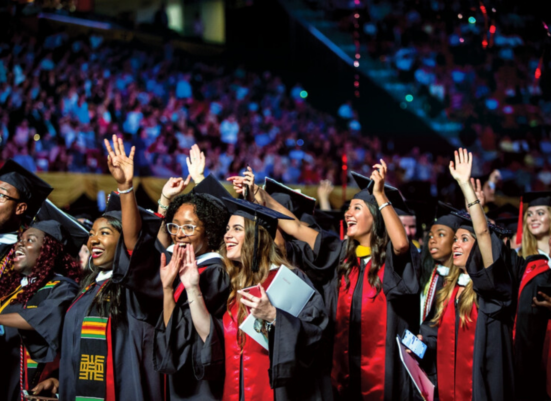 screenshot of graduates with arms raised